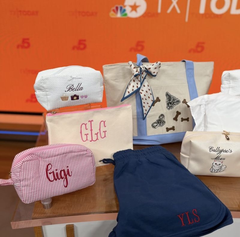 Personalized cosmetic pouches, a monogrammed tote, and embroidered shorts displayed on the Texas Today set